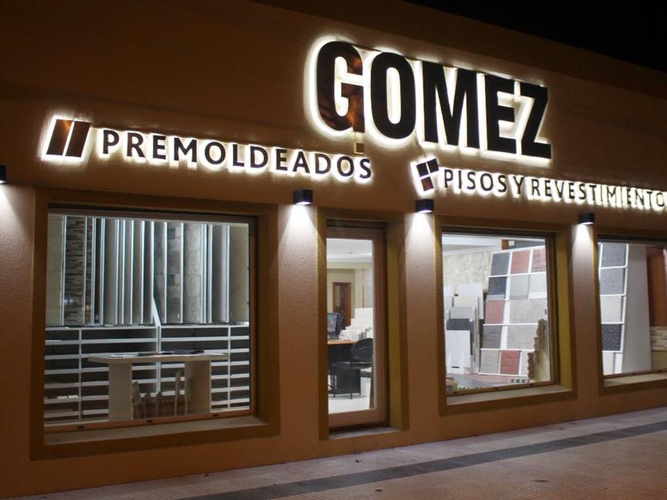 Frente del local de Pisos Gómez iluminado de noche